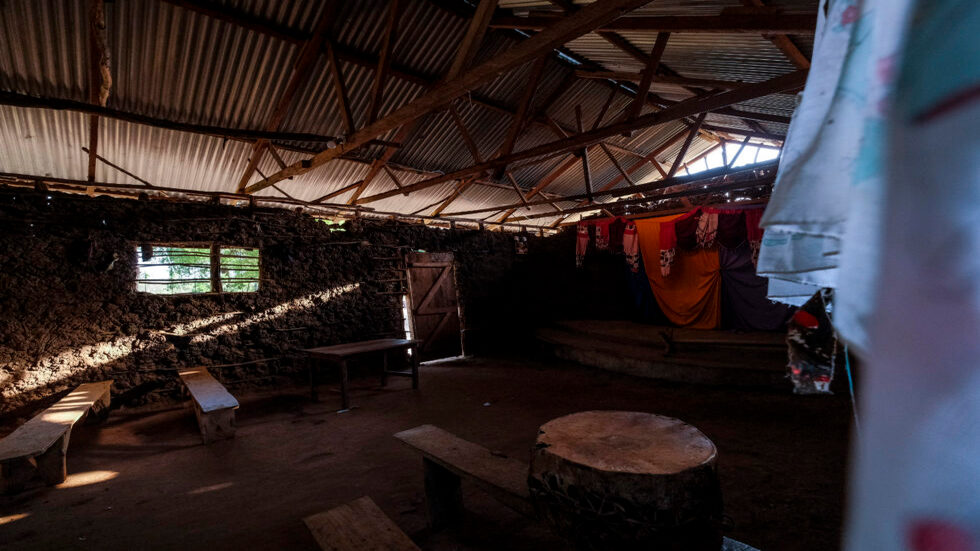 CAPTION in Shakahola, Kenya on 21 February, 2024. (Photo by Kabir Dhanji) A night dress hangs on a sturdy bed in a hovel in Shakahola. Lascivious artifacts litter the ruins of the camp, described by a neighbour as ‘Sodom and Gomorrah’. Many children were born in these hovels and never registered, killed and buried in the bush, disappearing without trace. A monastery it wasn’t.